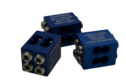 Three blue aluminum cable blocks with engraved warnings, four cable holes, and eight silver set screws on each block.