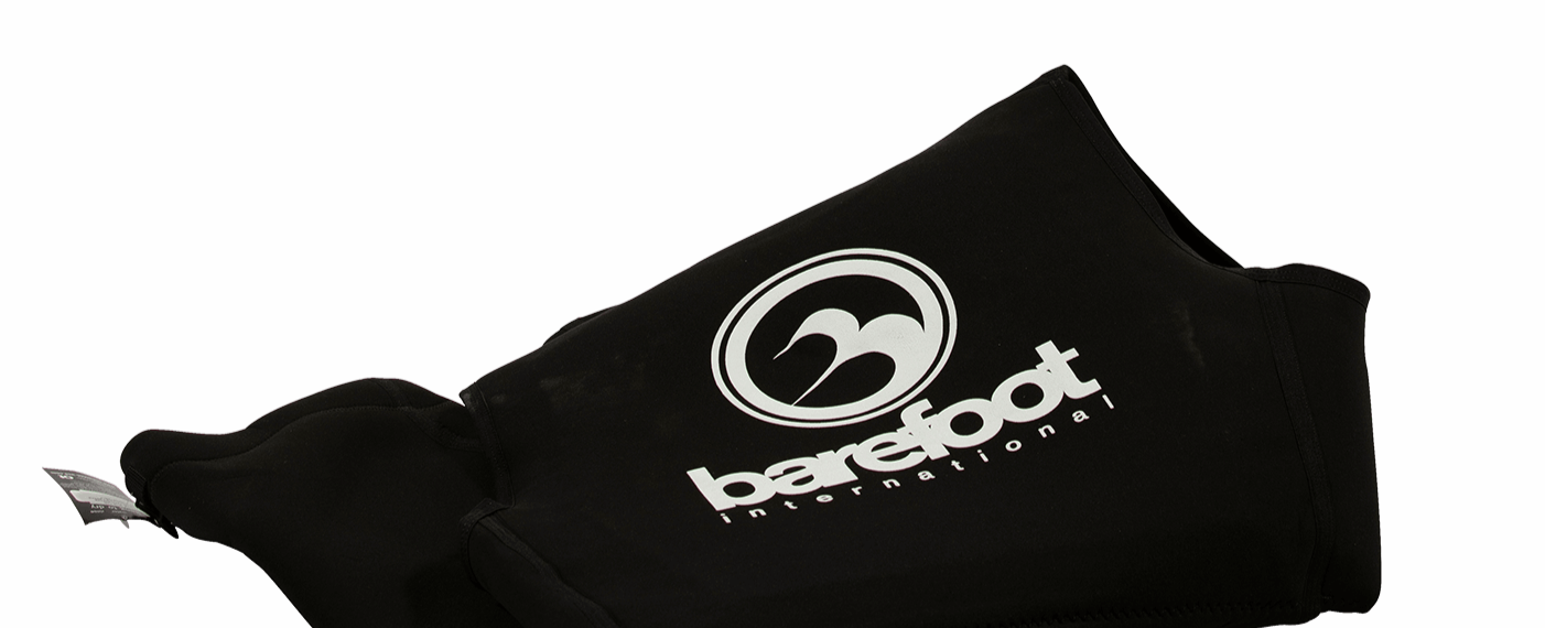 Close-up of the folded Iron Sleeveless wetsuit, highlighting the Barefoot International logo and stitching details.